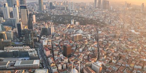 İstanbul'un havadan görünümü: önde Şişli-Beyoğlu'nun sık dokulu kiremit çatılı apartmanları, arkada Levent'in gökdelenleri