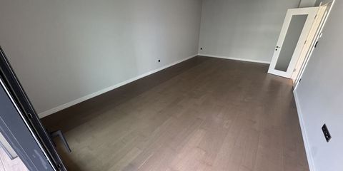 Boş bir dairenin salonunda yerde duran karton kutular ve pencereden vuran gün ışığı