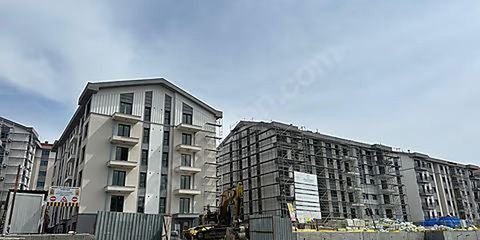 Tapu müdürlüğü önünde elinde dosya ve tapu senedi tutan bir kişinin yakın plan görüntüsü